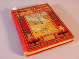 un livre rouge sur lequel figure l'image d'un homme et d'un chien