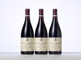 three bottles of red wine sitting on top of a table