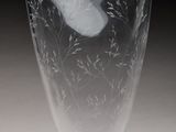 un vase en verre avec un oiseau sur une table