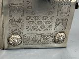 a silver metal box with a design on it