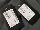 two tags are attached to the back of a gray jacket