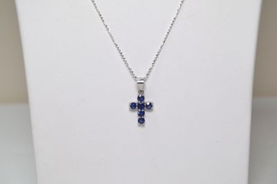 a close up of a necklace on a mannequin with a cross on it