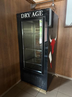 a dry age refrigerator in the corner of a room