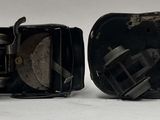 two pieces of black and silver metal on a white surface