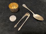 two spoons and a spoon rest on a table next to a coin