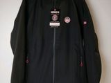 un gros plan d'une veste noire accrochée à un mur
