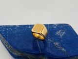 une image représentant une bague en or posée sur une pierre bleue