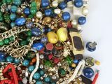 a pile of assorted jewelry on a white surface