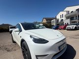a white tesla car parked in a parking lot next to a building