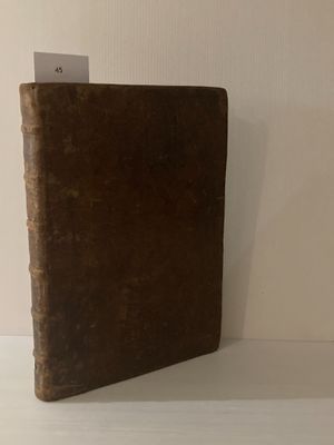 un livre marron posé sur une étagère blanche