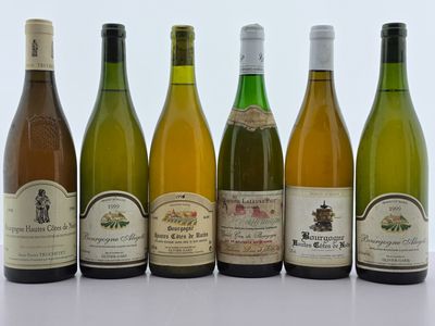 six bouteilles de vin sont alignées sur une table
