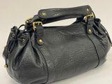 a black purse with gold hardware on the handle