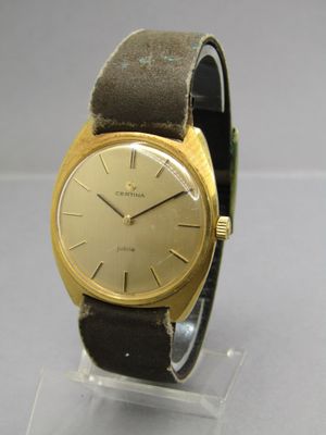 une photo d'une montre-bracelet en or posée sur un socle transparent