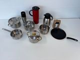 a lot of pots and pans that are on the table