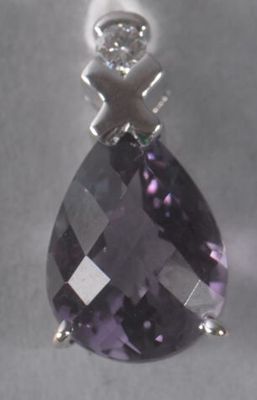 Un pendentif en améthyste et diamant est suspendu à une chaîne en argent