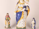 an image of a statue of a woman holding a child and three figurines