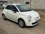 a small white car that is parked in a parking lot