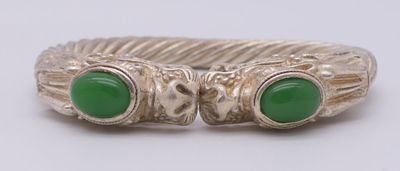 un gros plan d'une bague ornée de deux pierres vertes
