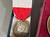a medal in a red, white, and blue box