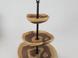 a three tiered tray with wooden slices on it