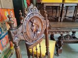 a wooden chair that has a carved head on it