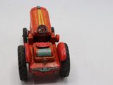 un petit tracteur rouge avec un volant, posé sur une surface blanche