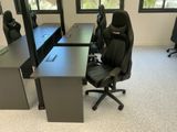 une chaise de bureau noire placée devant deux bureaux