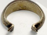 an image of a gold bracelet with a blue stone in the middle