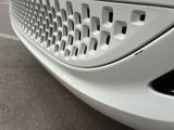 a close up of a car ' s grille with a cat sitting on it