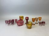 de nombreux verres et vases de différentes couleurs sur la table
