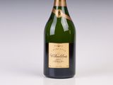 an old bottle of champagne sitting on top of a white table
