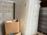 deux cartons de matelas posés sur une palette dans un entrepôt