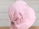 a pink hat that is sitting on top of a wooden table