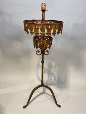 brass candle stand with a candle on top of it on a white background