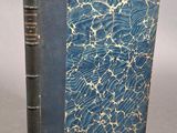 un vieux livre à la couverture bleue posé sur une table