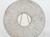 marble sculpture of a circular object on a metal stand on a white surface