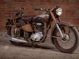 a old motorcycle that is parked in front of a brick wall