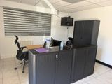 un bureau équipé d'un bureau, d'armoires et d'une télévision