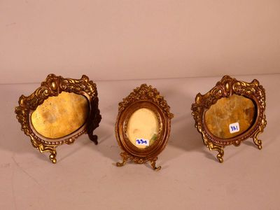 trois cadres dorés posés les uns à côté des autres sur une table
