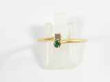 a close up of a gold ring with a green stone on it