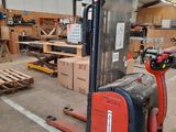 a fork lift truck in a warehouse with boxes on the floor