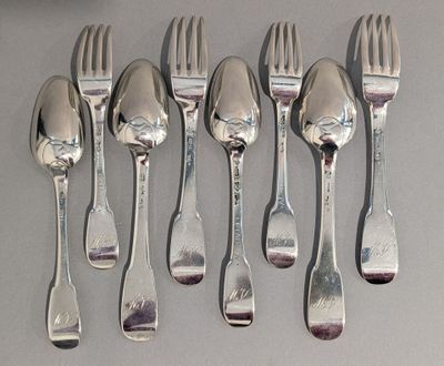 six fourchettes et six cuillères sur une table