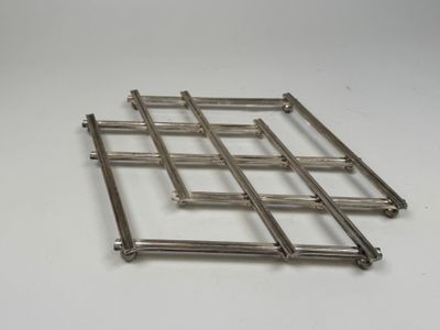 un gros plan d'une grille métallique sur une surface blanche