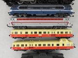 cinq trains de couleurs différentes posés sur une surface blanche