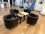 trois chaises noires et une table au milieu d'une pièce