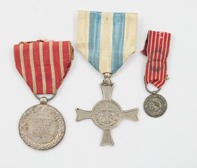 deux médailles et une médaille sont posées sur une surface blanche