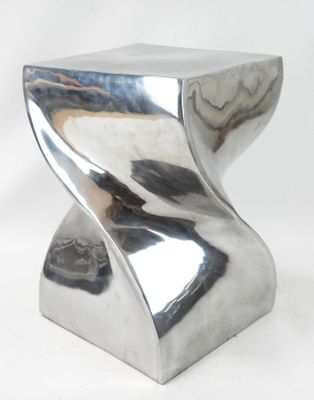 un tabouret argenté posé sur une surface blanche