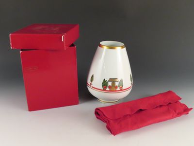 une boîte rouge avec un vase blanc et une serviette rouge