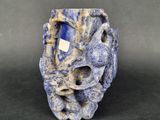 a close up of a blue and white vase on a black surface