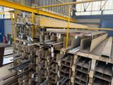 a large pile of steel beams in a warehouse